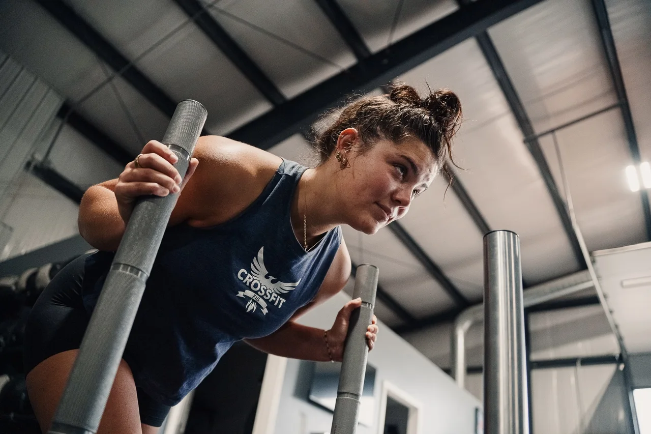 Close-up of an athlete leaning forward and gripping the sled handles at CrossFit Fig.